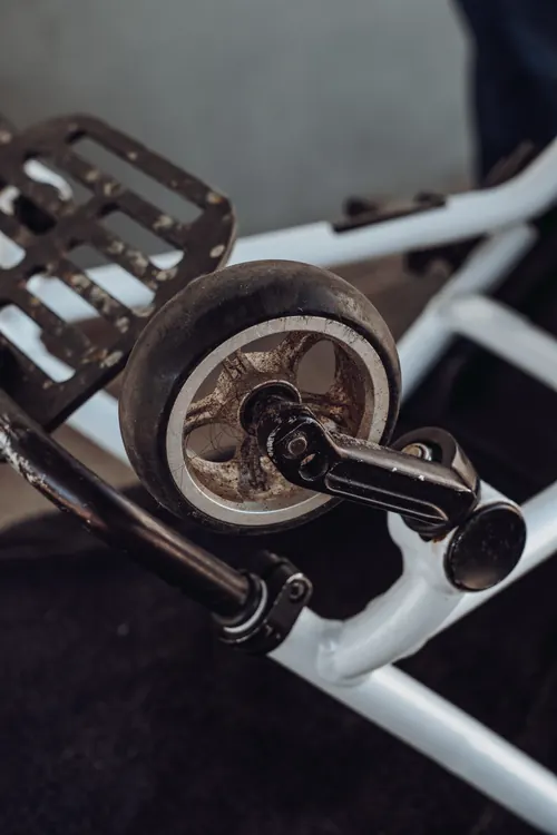 A wheelchair castor wheel before cleaning, with hair and grime around the hub.